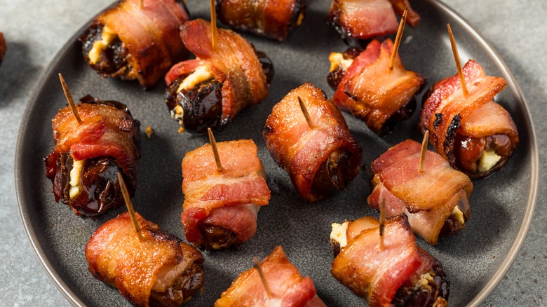 Bacon-wrapped, goat cheese-stuffed dates on plate