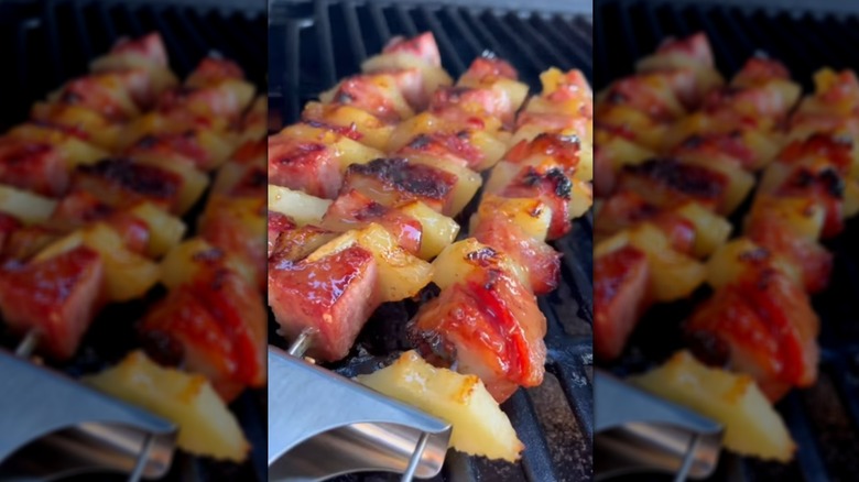 Ham and pineapple skewers cooking on grill