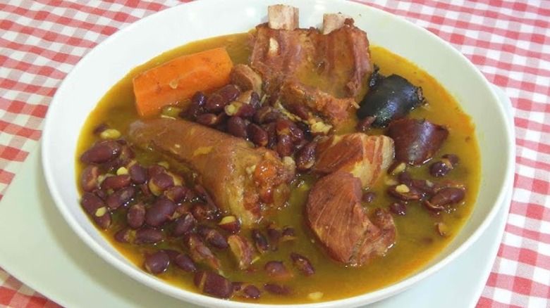 white bowl with Olla podrida on red and white checked tablecloth