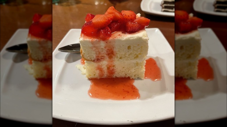 Slice of strawberry cream cake at Olive Garden on a white plate