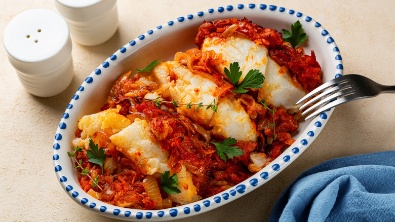 baked cod in tomato sauce, shown in an oval baking dish