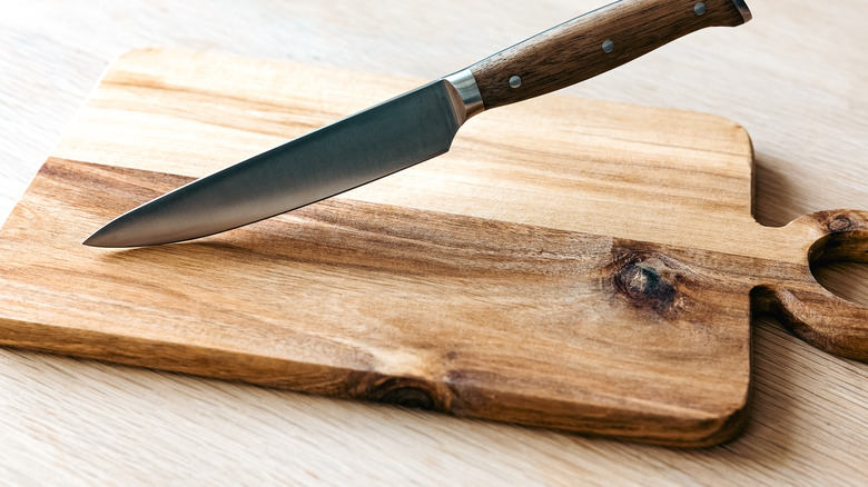 A wooden cutting board and a knife