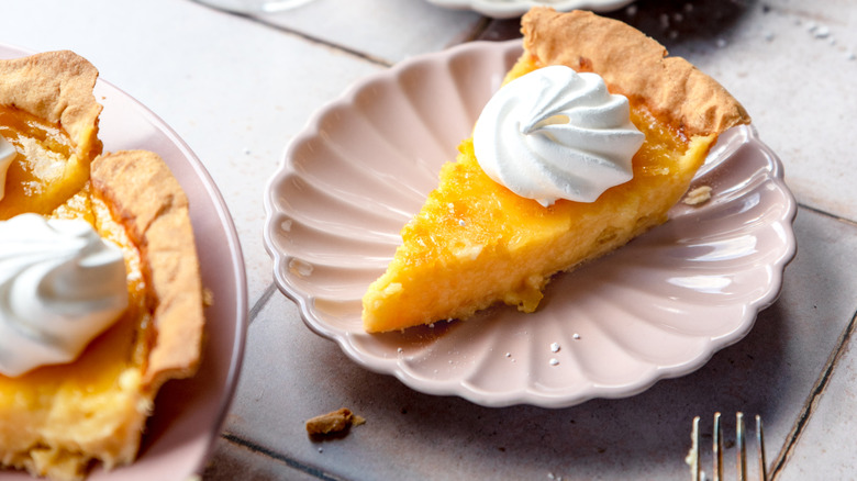 Meringue-topped slice of lemon pie on pink plate