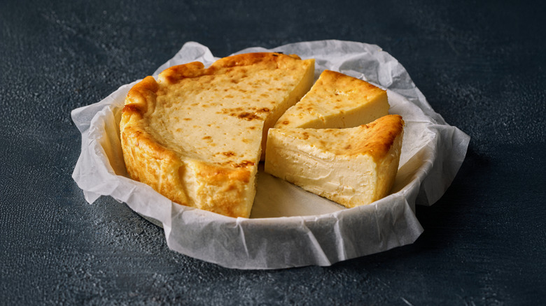 Sliced basque cheesecake in parchment-lined baking pan