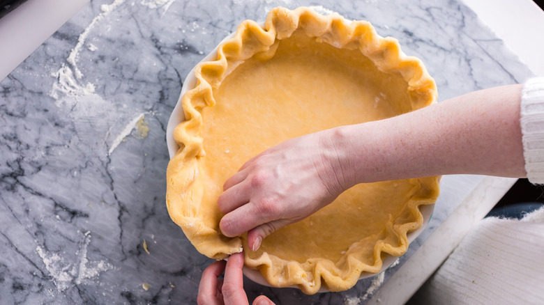 Crimping pie dough in pie dish