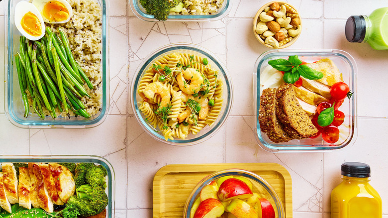 view of glass food containers filled with salads, sandwiches, and vegetable dishes