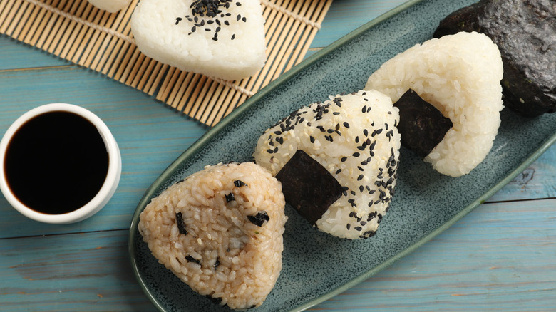 rice balls onigiri on a clean blue plate with sauce
