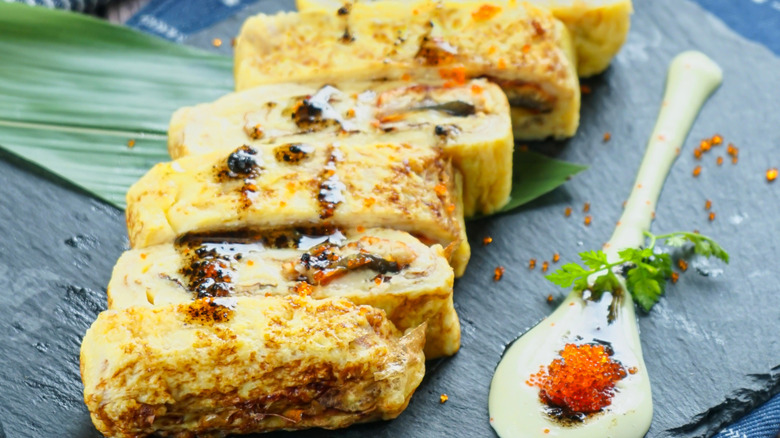 nori omelet on a dark plate with sauce