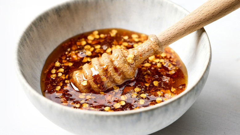 A bowl of hot honey with chile flakes in it