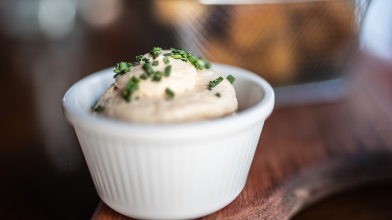 A dipping sauce bowl with creamy aioli on a table