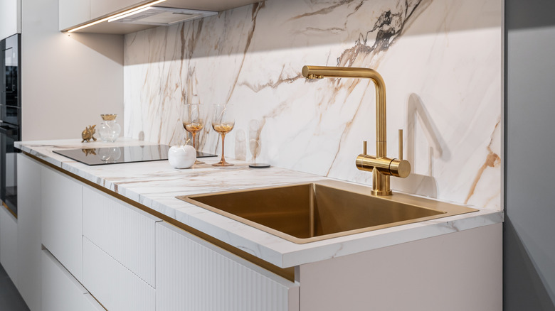 Stylish kitchen faucet against marble countertop and backsplash
