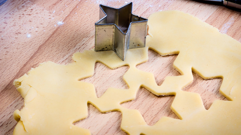 Cutting out pastry stars on wooden countertop