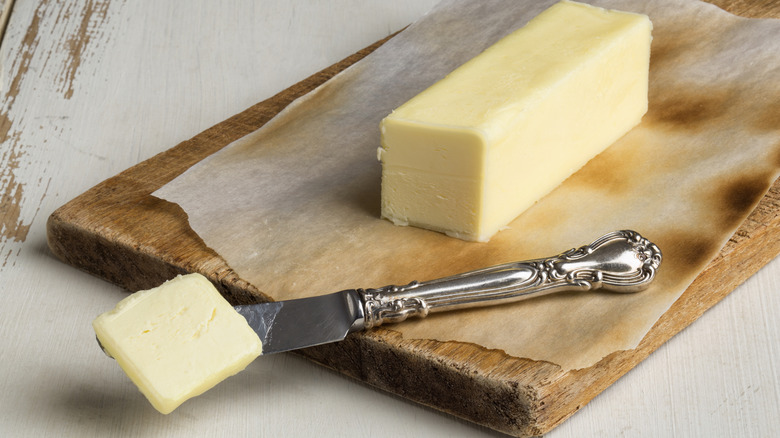 Slicing stick on butter on parchment-lined wooden cutting board