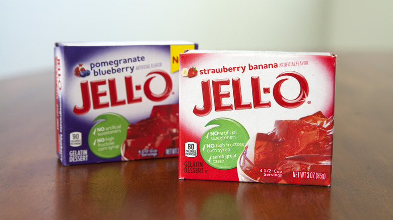 Boxes of strawberry banana Jell-O and pomegranate blueberry Jell-O standing on wooden surface