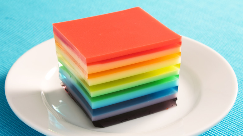 Square of multicolored layered Jell-o dessert on plate