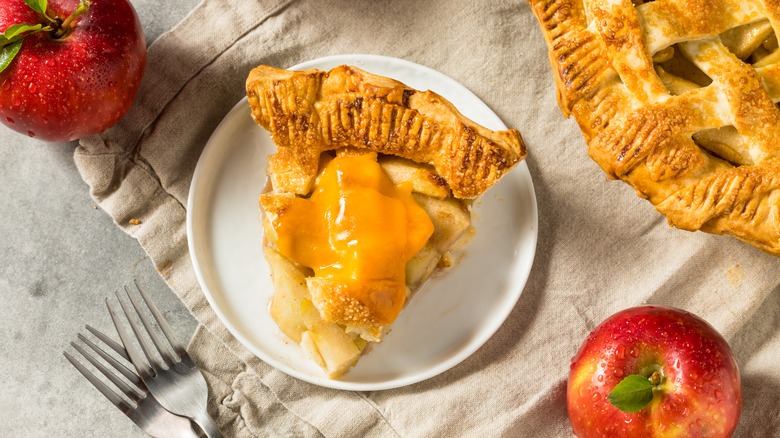 Sweet apple pie topped with a slice of cheddar cheese