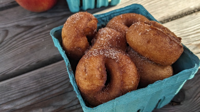 Apple cider donuts next to freshly picked apples