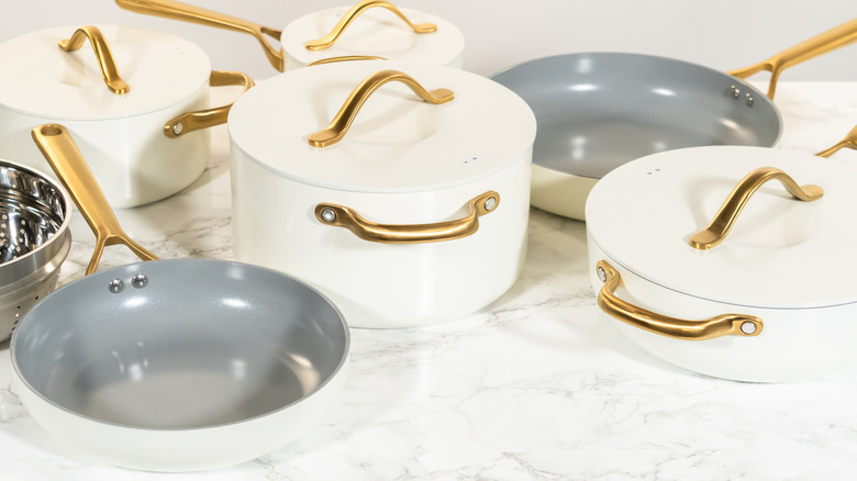 Collection of white and gold ceramic pots and pans