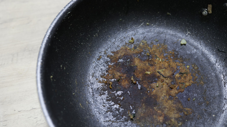 Closeup of burnt food in a cooking pan that stuck to the bottom