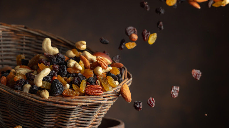 Dried fruit and raw nuts thrown into a woven basket