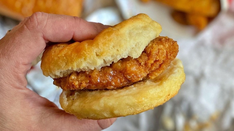 Hand holding Wendy's honey butter chicken biscuit