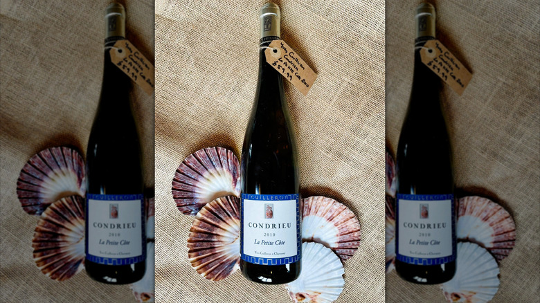 bottle of white Cave Yves Cuilleron wine with shells laid out on rattan