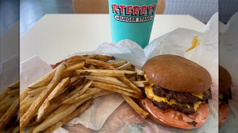 A photo of P. Terry's Burger Stand burger, fries, and a drink on dining table