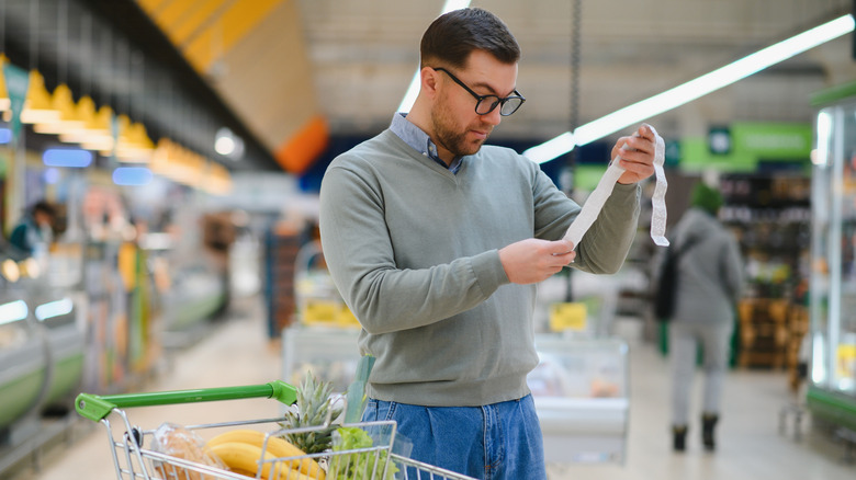 A man reading grocery store reciept