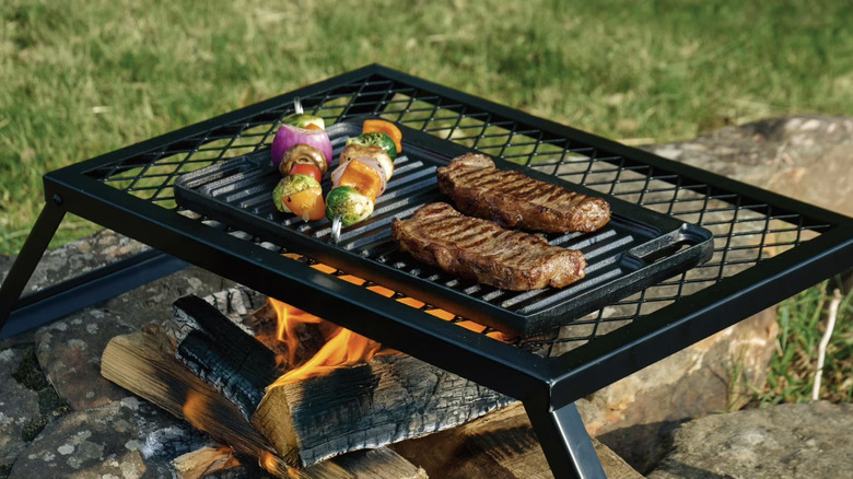 Ozark Trail Deluxe Cast Iron Reversible Grill Griddle Plate over campfire