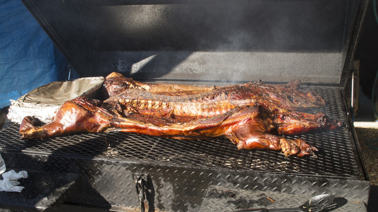 A whole hog cooking on a barbecue