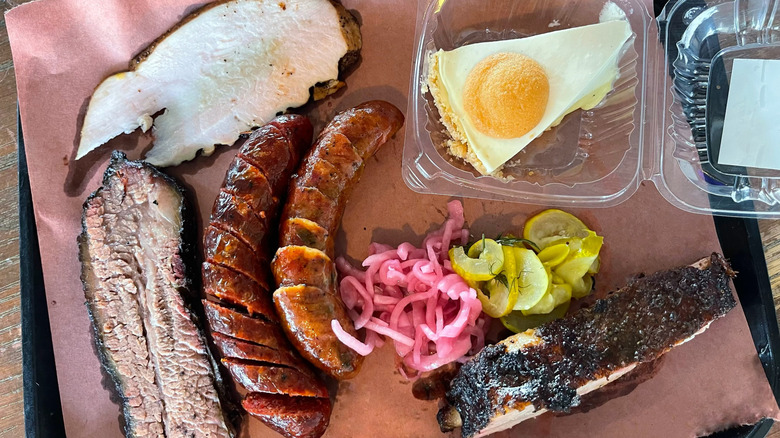 A tray of barbecue from Lewis with pickles and a slice of banana pie