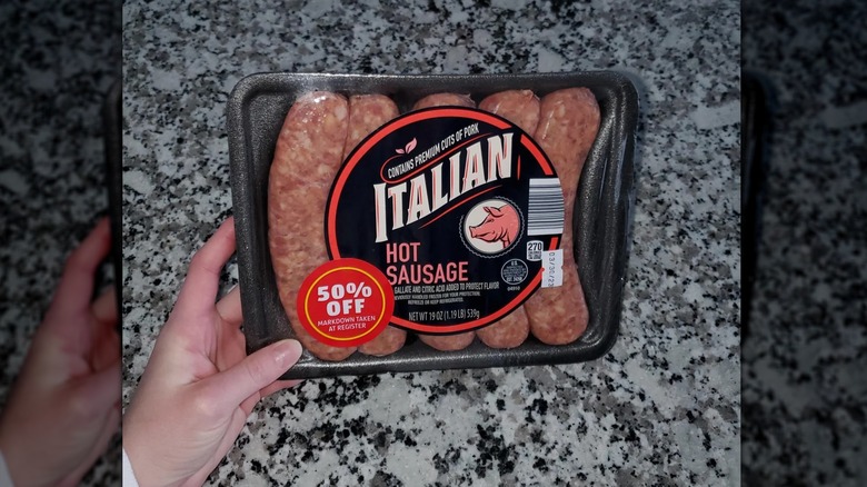 Hand holding the hot Italian sausages