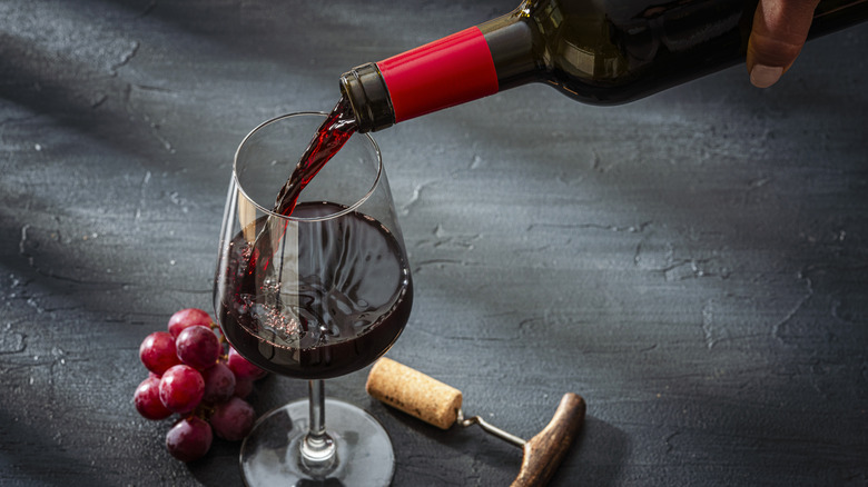 Pouring a glass of wine from a wine bottle.