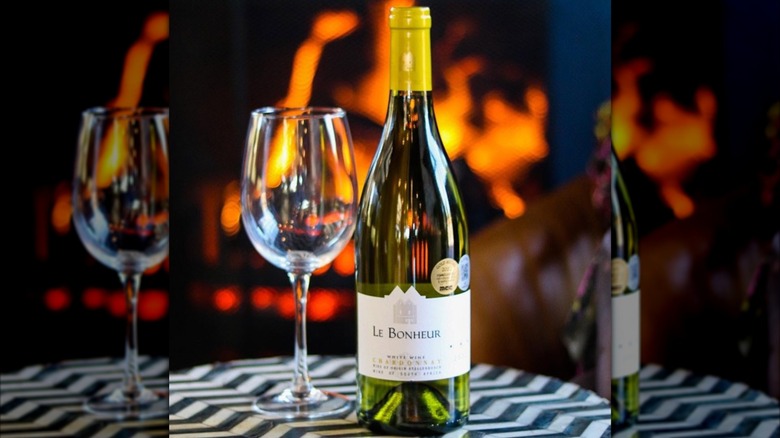 bottle of white wine and glass in front of fire
