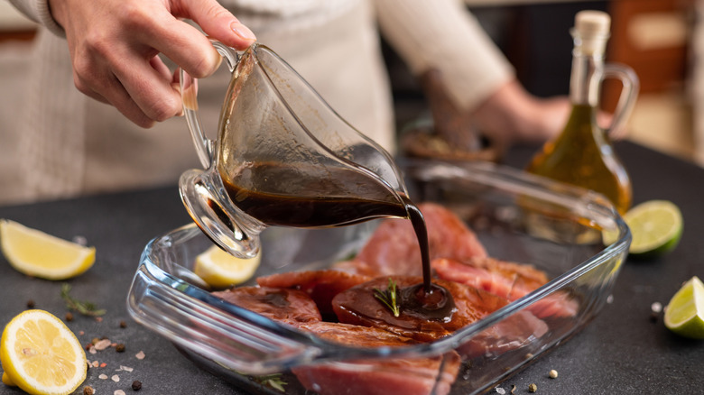 Lemon juice marinade being poured over meat