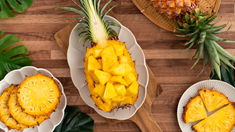 Freshly cut pineapple pieces inside a halved pineapple