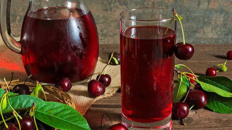 Glass of tart cherry juice surrounded by cherries