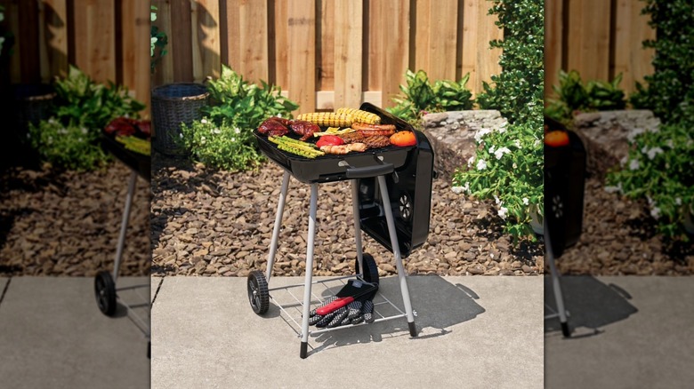 Expert Grill 17.5-inch charcoal grill on sidewalk grilling meat and veggies