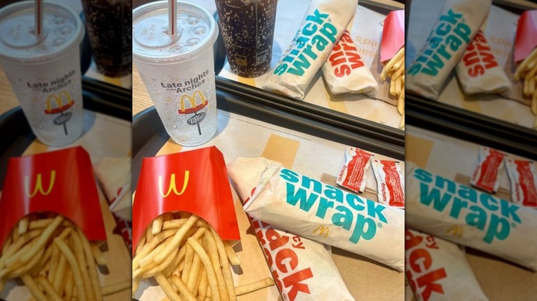 Two orders on McDonald's trays each with two snack wraps and medium fries and a drink