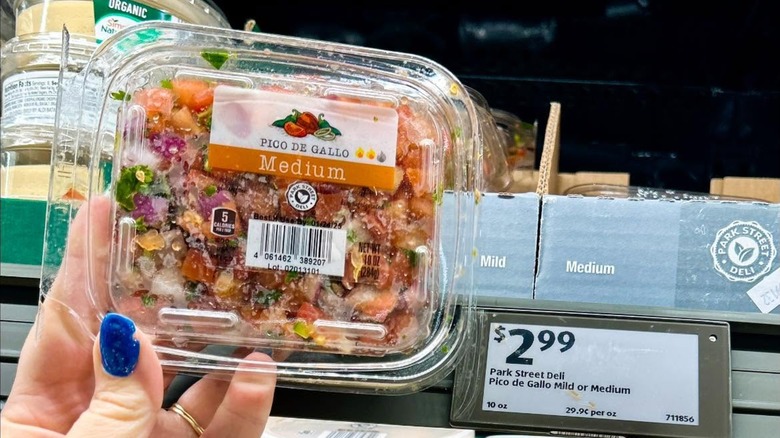 Hand holding Park Street Deli pico de gallo in deli case