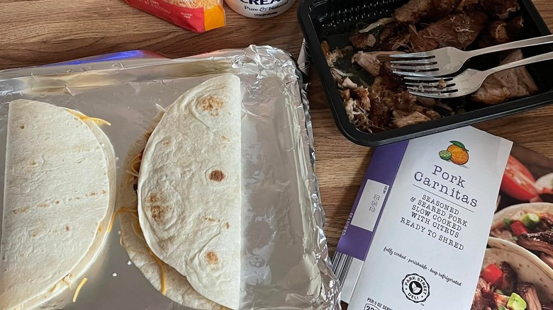 Open package of Park Street Deli pork carnitas with tortillas, cheese, and condiments