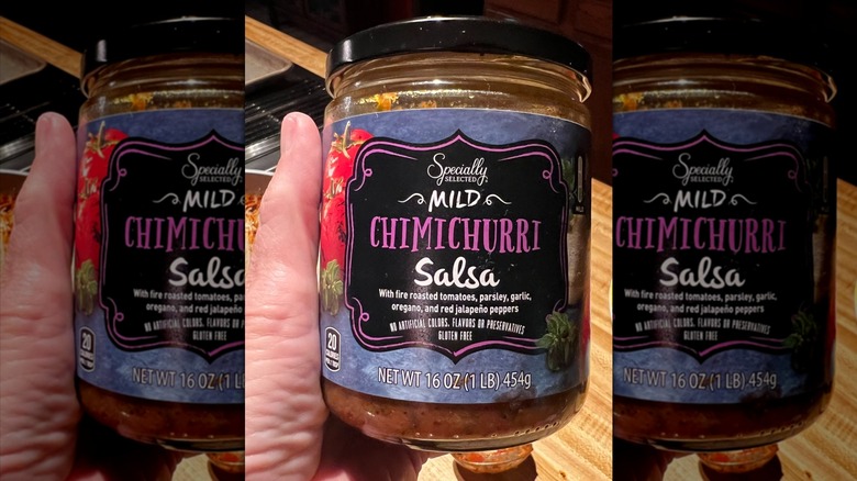 Hand holding jar of Specially Selected chimichurri salsa
