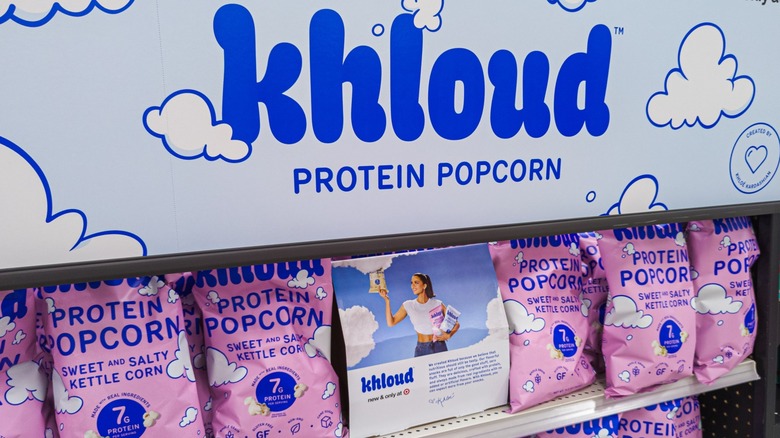 Pink bags of Khloud protein popcorn on grocery store display shelf