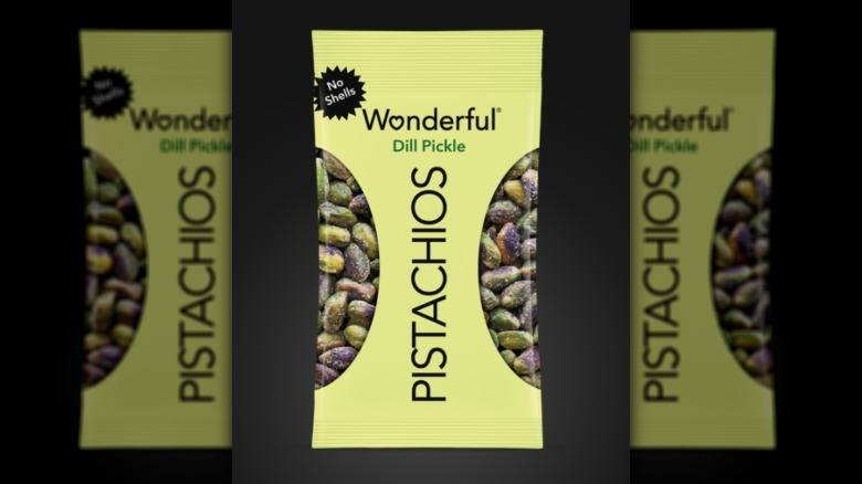 Green package of dill-flavored pistachios placed on a wooden surface