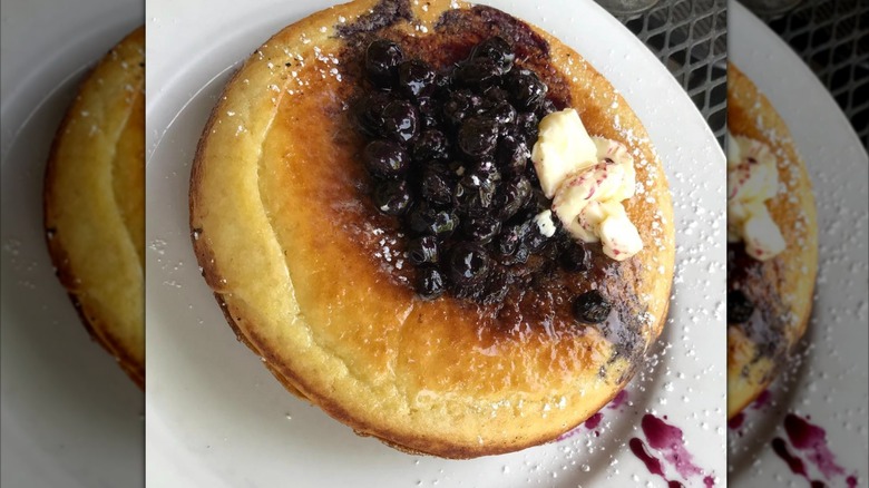 German pancake with blueberry compote on white plate