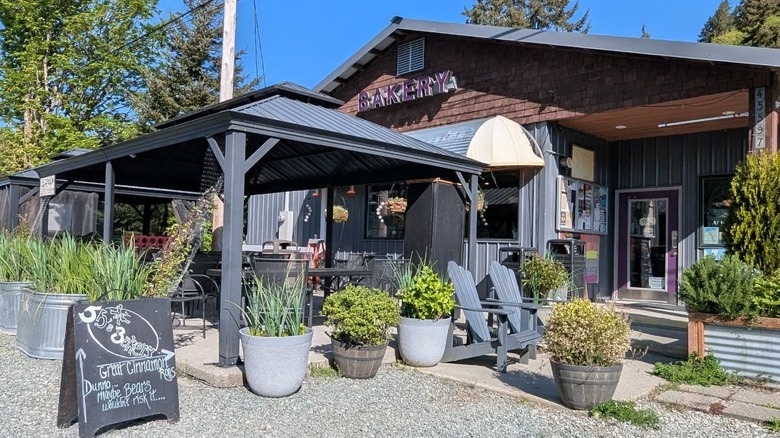 Wooden bakery with outdoor seating and a blue sky behind it