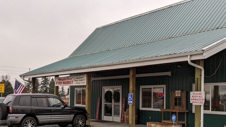 Skagits Own Fish Market green building with a car outside on a rainy day