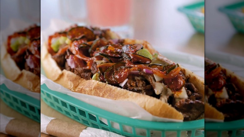 Close-up of Yumbii cheesesteak in mint green basket