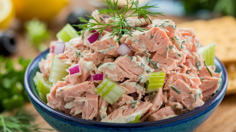 Bowl of tuna salad with red onion, herbs, and celery