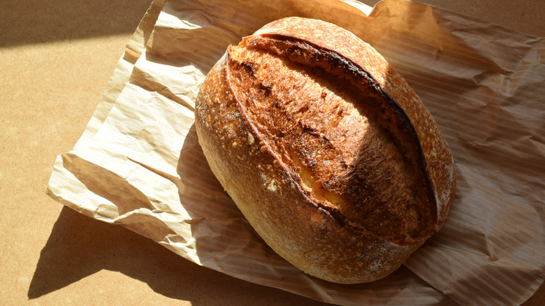 Top view of a loaf of sourdough on a paper bag